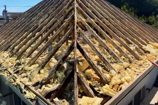Roof with spray foam insulation removed by experienced Plymouth Roofers 